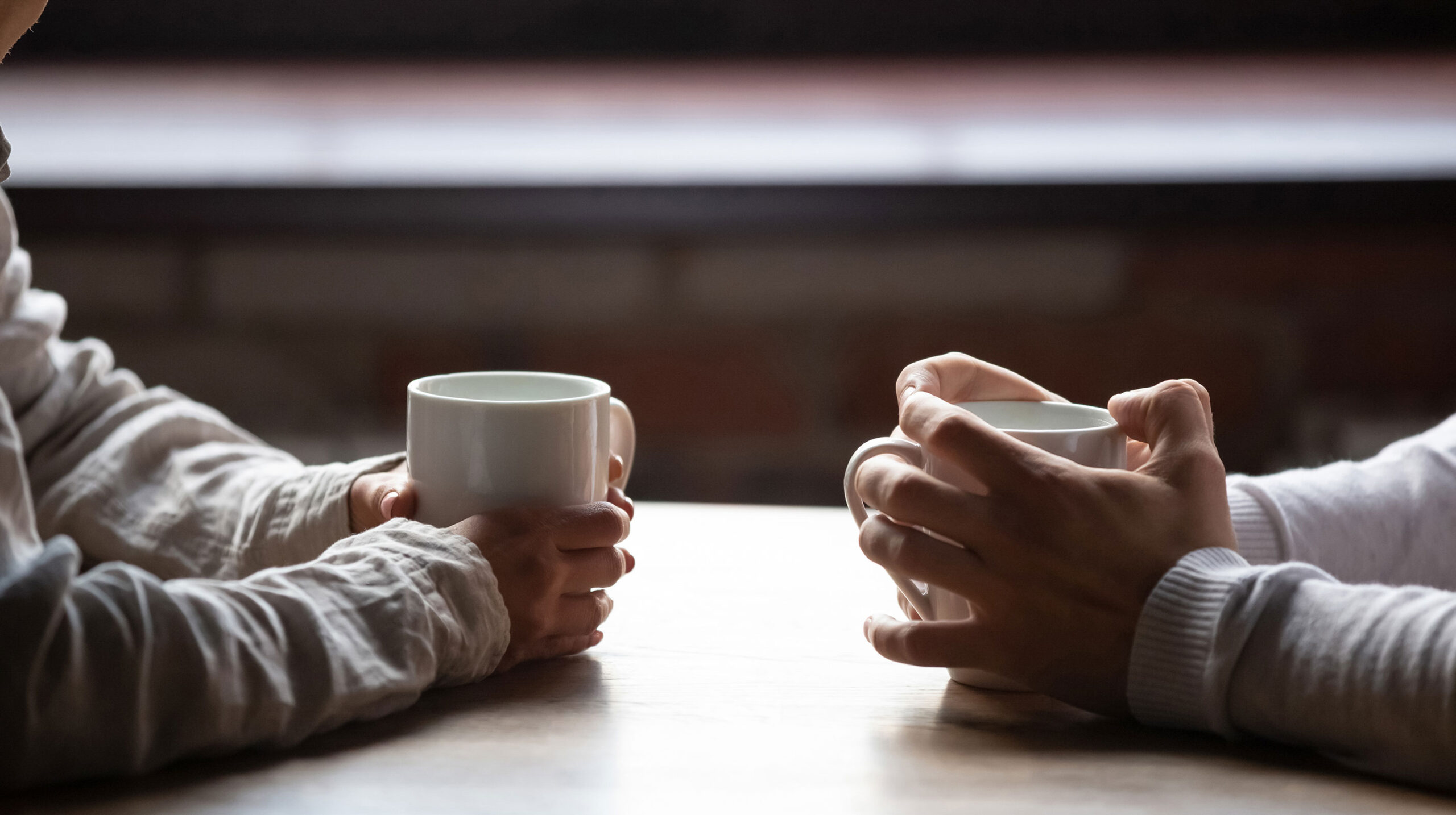 close-up-woman-man-holding-cups-coffee-table